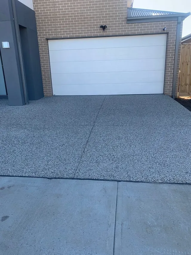 Plain concrete driveway leading to a garage